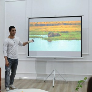 HOMCOM Beamer Leinwand, 84 Zoll, mit Mann vor der Leinwand. Ideal für Heimkino und Präsentationen.