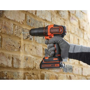 Black+Decker Akku-Schlagbohrschrauber beim Bohren in eine Ziegelwand.