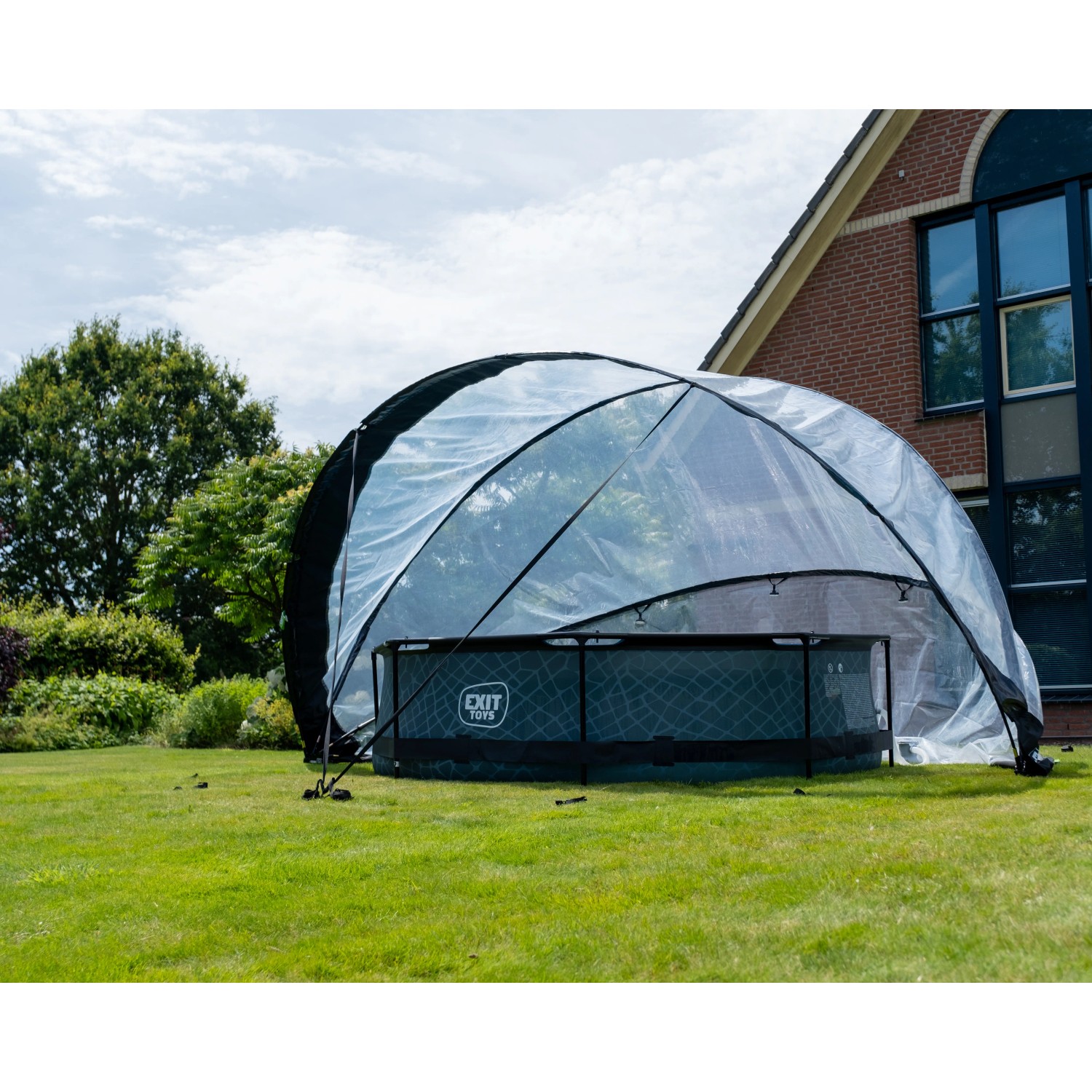 Exit Pool Abdeckung ECO Ø 460 cm auf Rasen vor Haus, transparente Poolüberdachung.