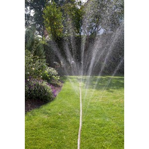 Gardena Schlauchregner 15m in Orange bewässert Rasenfläche im Garten.