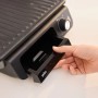 Grauer Braun Multigrill mit Fettauffangschale in der Hand.