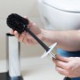 Hände montieren schwarzen Kunststoff WC-Bürstenkopf an Metallgriff. Ersatzbürste für WC-Bürsten Set.