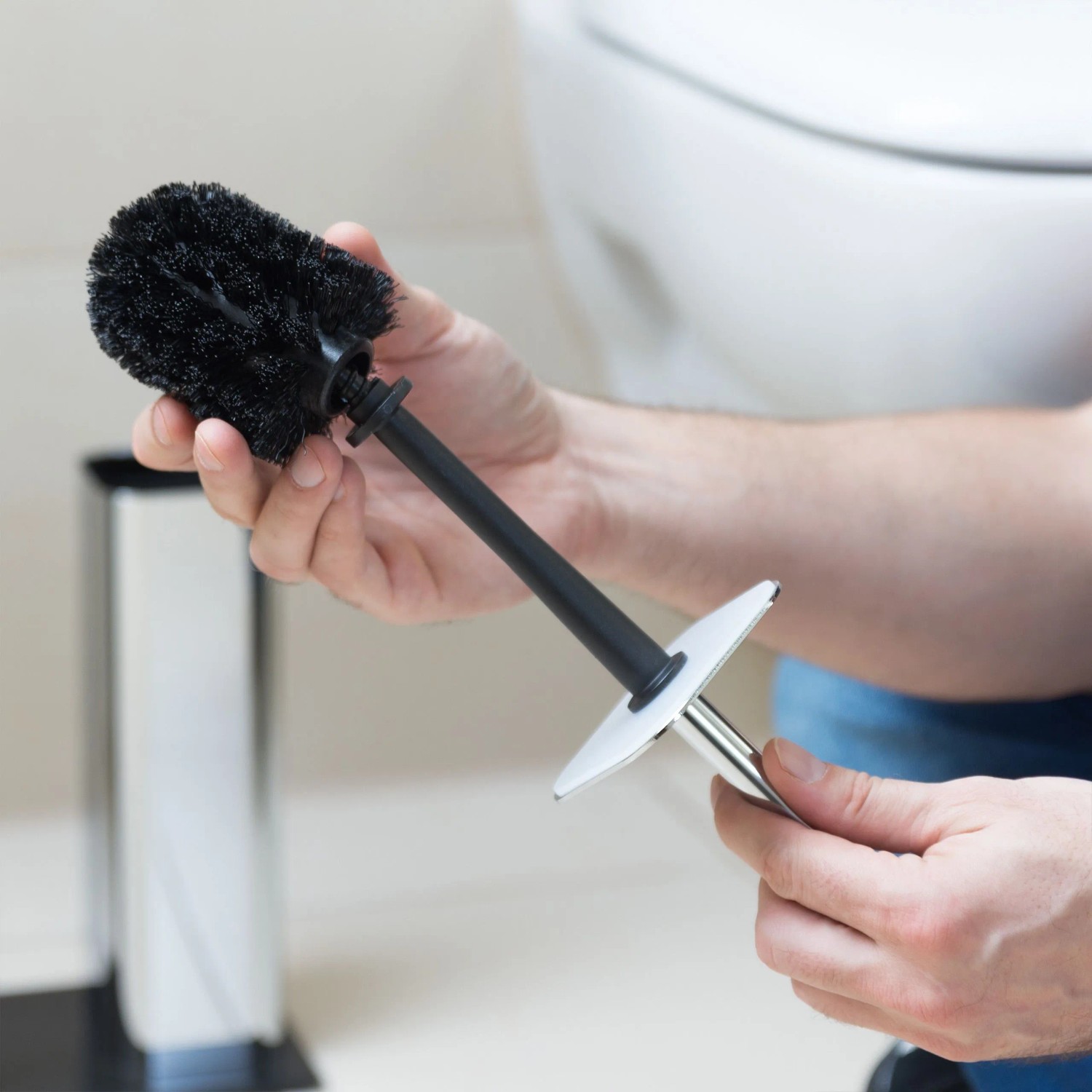 Hände montieren schwarzen Kunststoff WC-Bürstenkopf an Metallgriff. Ersatzbürste für WC-Bürsten Set.