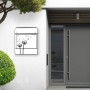 Schwarzer Design Briefkasten mit Pusteblumen Motiv und Zeitungsfach an einer weißen Hauswand.