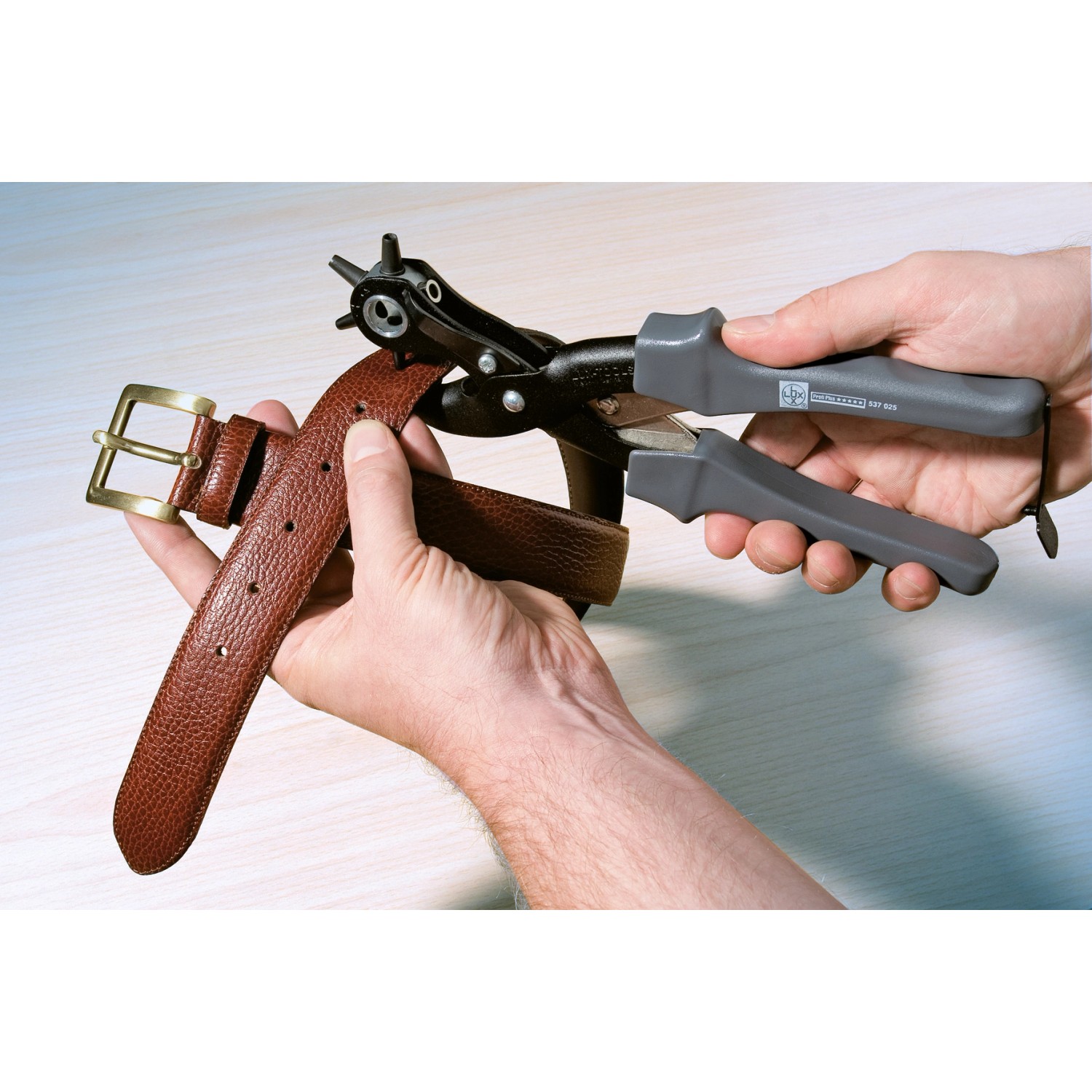 LUX Revolverlochzange 250 mm Professional beim Lochen eines Ledergürtels.