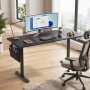 Schwarzer, elektrisch höhenverstellbarer Songmics Schreibtisch (160x120x70 cm) mit Zubehör im modernen Arbeitszimmer.