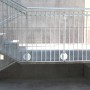 Montiertes Treppengeländer aus Metall mit Betonschrauben an einer Betontreppe und -wand.