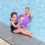 Mädchen mit lila Bestway Wasserball mit Ananas-Motiv am Pool, Mutter im Hintergrund.