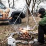 Petromax Dreibein mit Kette über Lagerfeuer beim Kochen. Grillutensil für Outdoor-Küche.