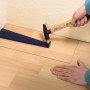 LUX Zugeisen Classic im Einsatz zum Verlegen von Laminat/Parkett an der Wand.