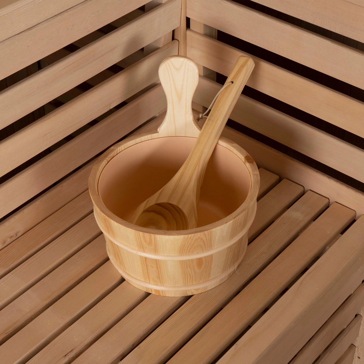 Sauna SKYLINE Zubehör: Holzkübel und Schöpfkelle aus Tannenholz auf Saunabank.