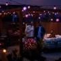 Philips Hue Festavia Lichterkette mit bunten Globe Lampen im Garten mit feiernden Menschen.
