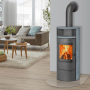 Thermia Kaminofen München V3, gussgrau mit Speckstein, im Wohnraum mit brennendem Feuer.