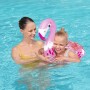 Mutter und Kind mit glitzerndem Bestway Schwimmring (Flamingo) im Pool.