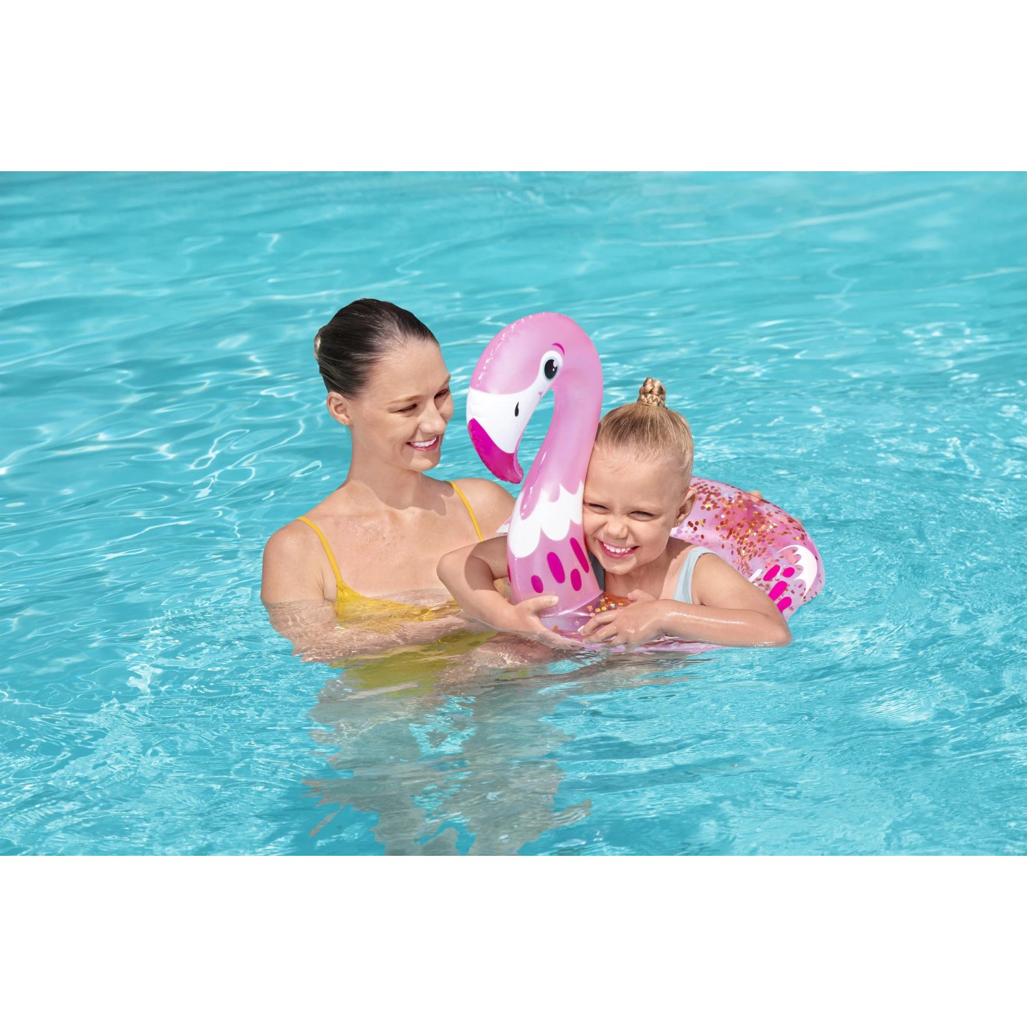 Mutter und Kind mit glitzerndem Bestway Schwimmring (Flamingo) im Pool.