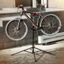 Schwarzer höhenverstellbarer Fahrradmontageständer mit Dreibein, hält ein Mountainbike zur Reparatur.