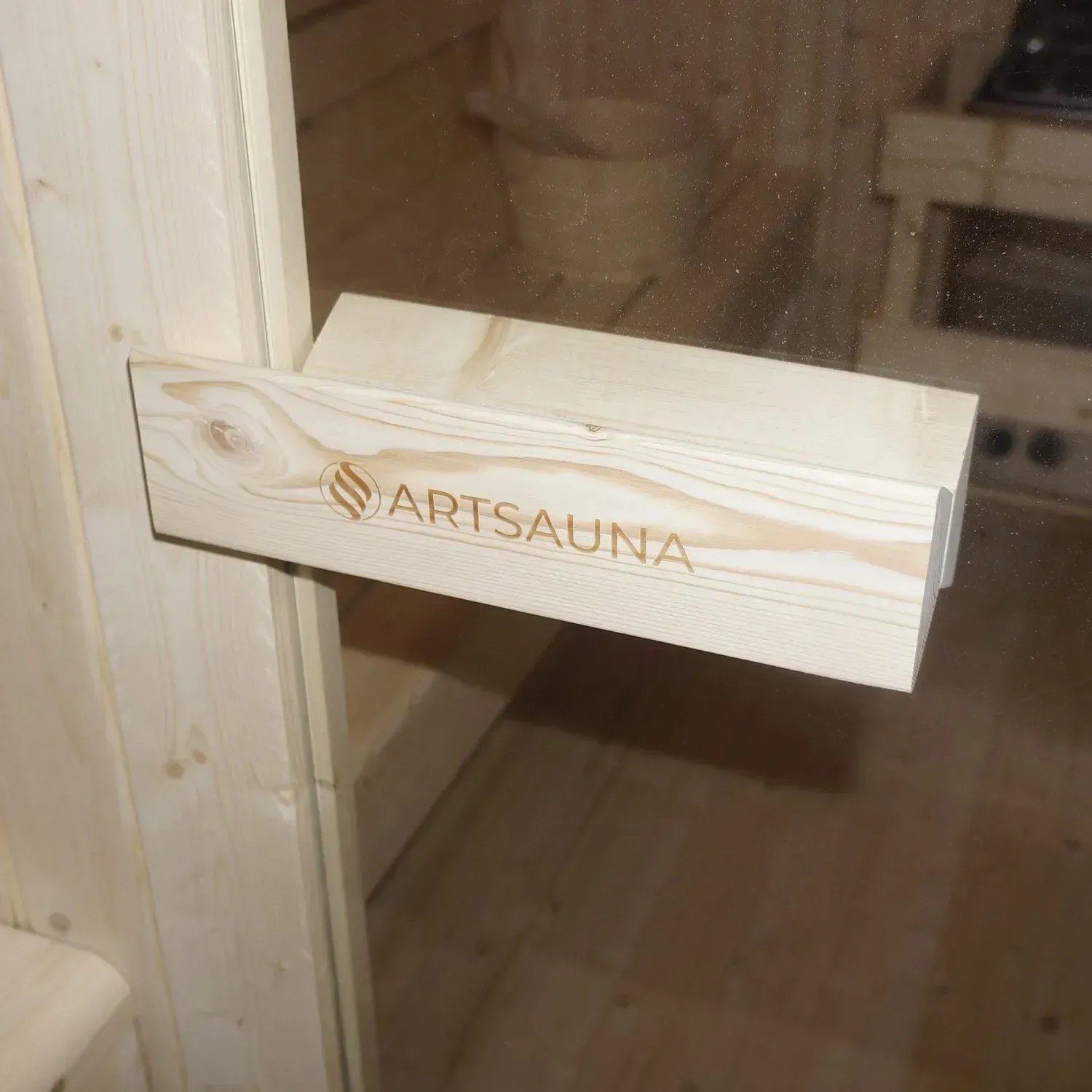 Detailaufnahme: Türgriff der Artsauna Cube Fasssauna Nolvik XXL mit Logo.