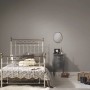 Graue Uni-Tapete von PROFHOME im Schlafzimmer mit Bett und Nachttisch.