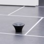 Schwarzer Wagner Bodentürstopper EH5202 aus Gummi zum Schrauben auf grauem Boden.