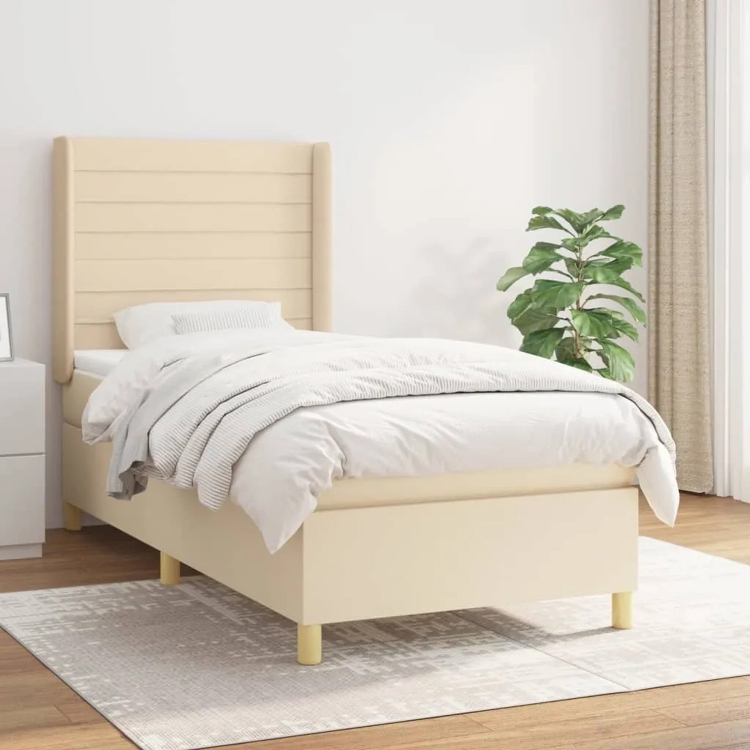 Cremefarbenes Boxspringbett 80x200 cm mit Matratze und Kopfteil im Schlafzimmer.