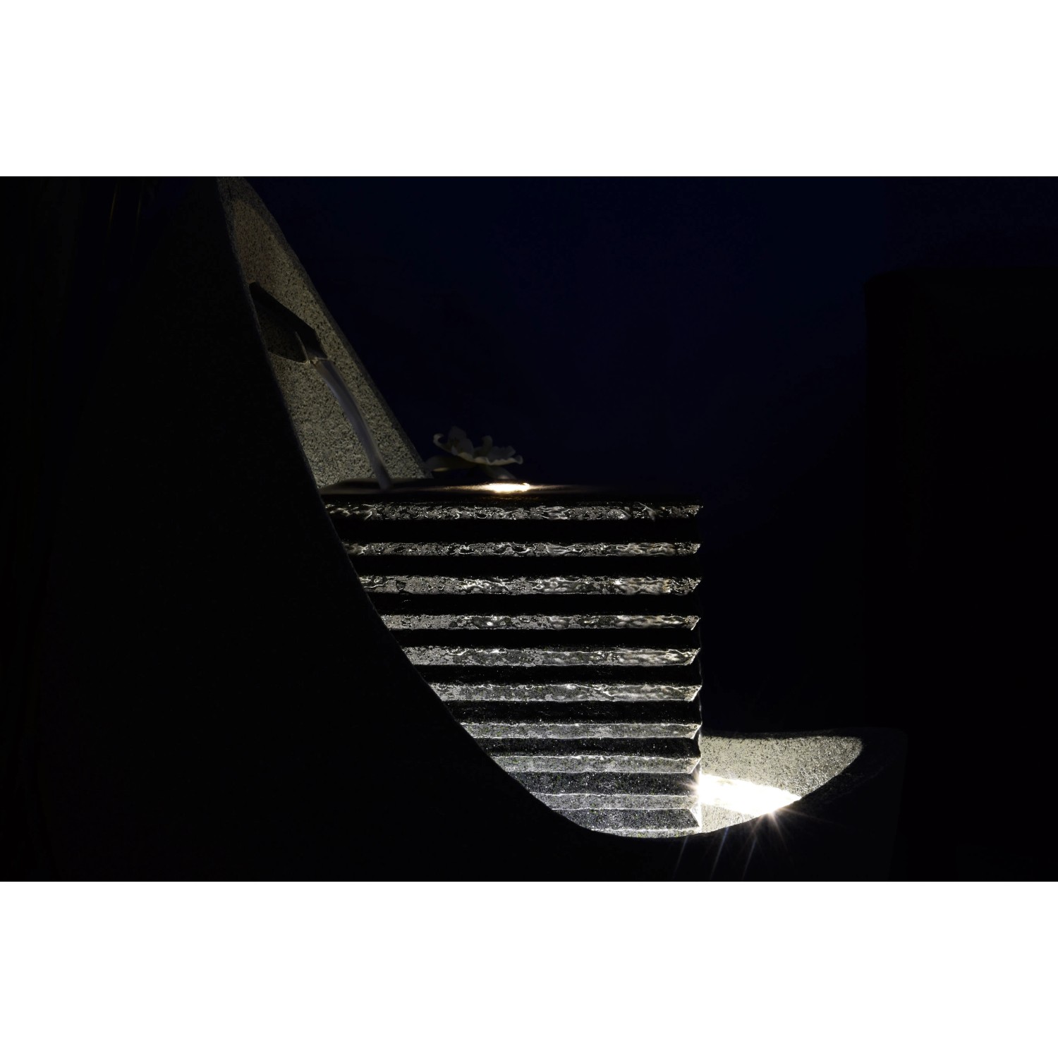 Großer, dunkler Design-Gartenbrunnen in Ei-Form mit LED-Beleuchtung.