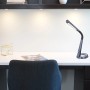 Schwarze LED-Tischleuchte Mitti von Globo auf einem Schreibtisch mit flexiblen Arm.