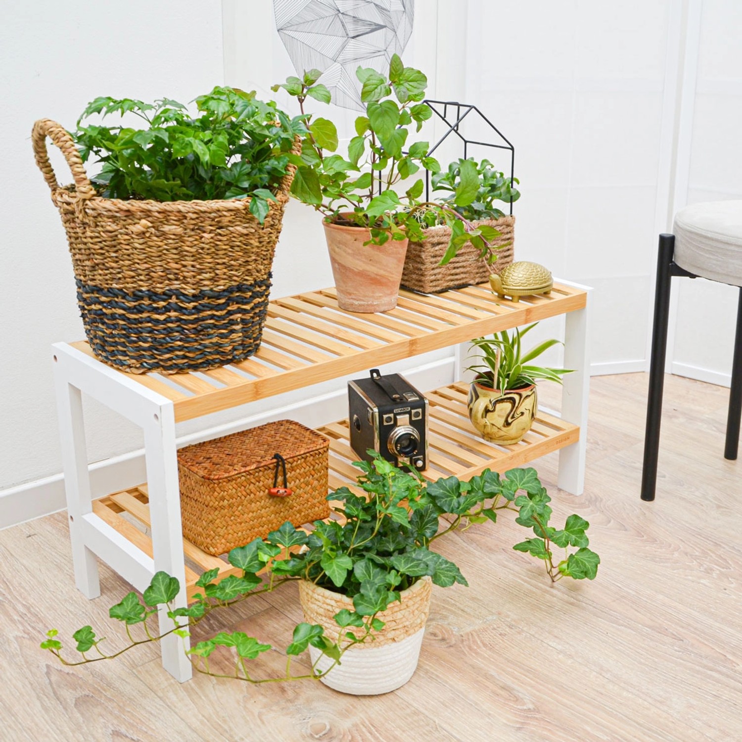 DuneDesign Schuhregal aus Bambus, weiß, mit zwei Ablagen, dekoriert mit Pflanzen und Deko.