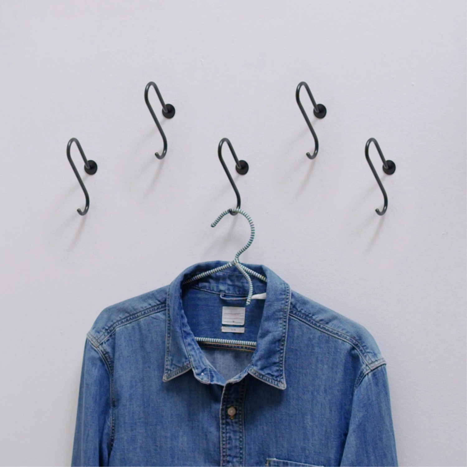 Schwarze Wagner Wandhaken Hooks4home Retro aus Stahl, 5er Set mit aufgehängtem Hemd.
