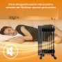 Schwarzer TroniTechnik Ölradiator TT OR 307 mit 7 Rippen und WiFi neben schlafender Person.
