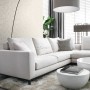 Beige Blätter Tapete von Origin Wallcoverings im Wohnzimmer mit Sofa und Lampe.