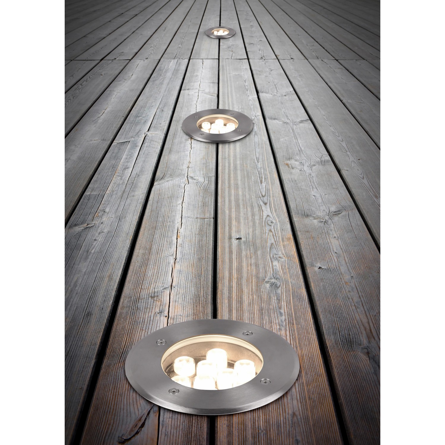 Trio LED-Bodeneinbaustrahler Belaja, Nickel matt, auf Holzterrasse. Runde Außenleuchte für Garten und Terrasse.