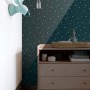 Dunkelblaue Vliestapete mit leuchtenden Sternen im Kinderzimmer. Die Glow-in-the-dark Tapete zeigt weiße Sterne.