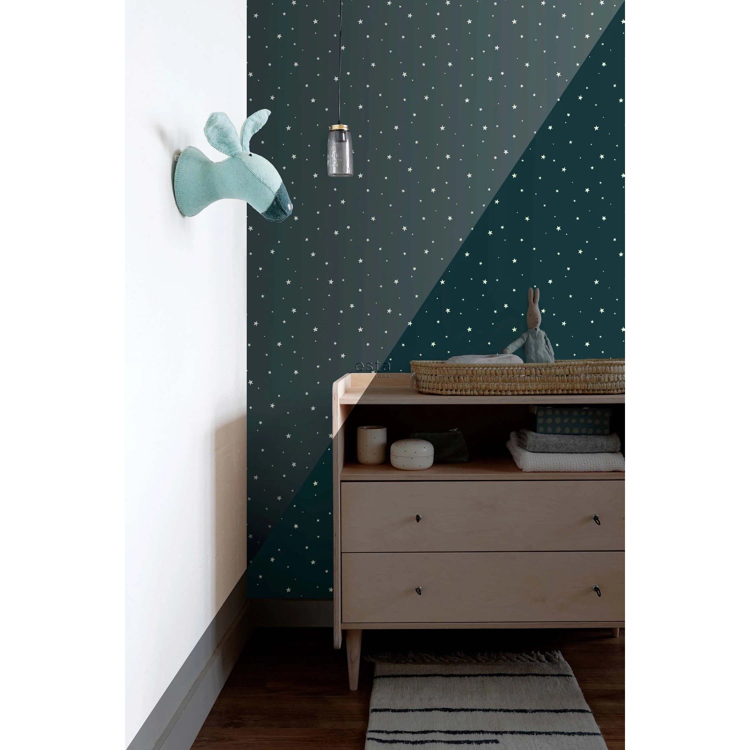 Dunkelblaue Vliestapete mit leuchtenden Sternen im Kinderzimmer. Die Glow-in-the-dark Tapete zeigt weiße Sterne.