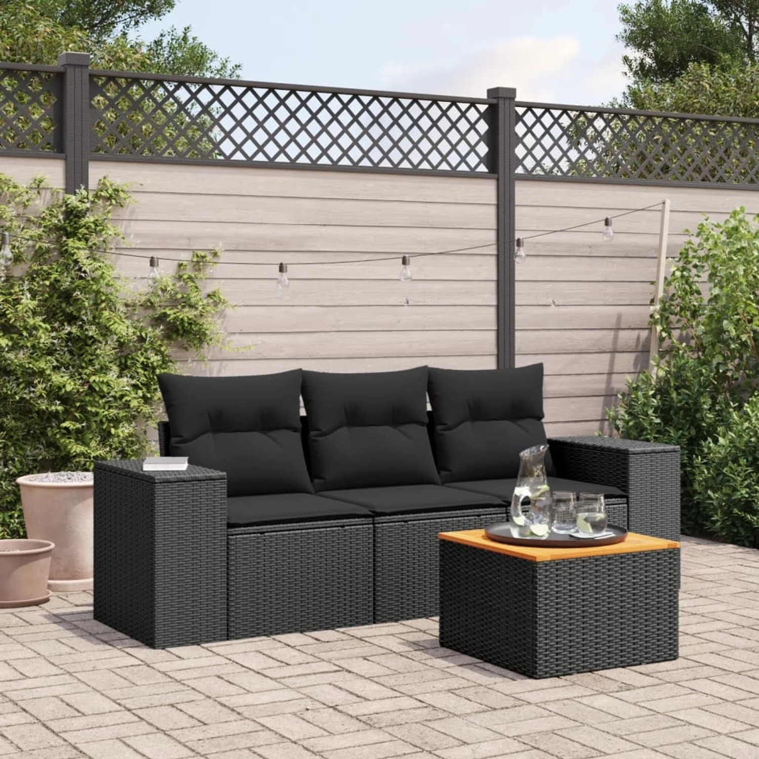 Schwarze 4-tlg. vidaXL Garten-Sofagarnitur aus Poly Rattan mit Tisch und Kissen.