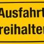 Gelbes Hinweisschild "Ausfahrt freihalten" für den Außenbereich.