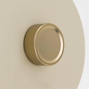 Detailaufnahme: Beige-schwarze Orion Wandleuchte mit Dimmer und messingfarbenen Akzenten.