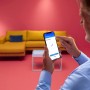 Mann steuert WiZ LED-Panel per App. Smarte Leuchte mit Tunable White Funktion für individuelles Licht.