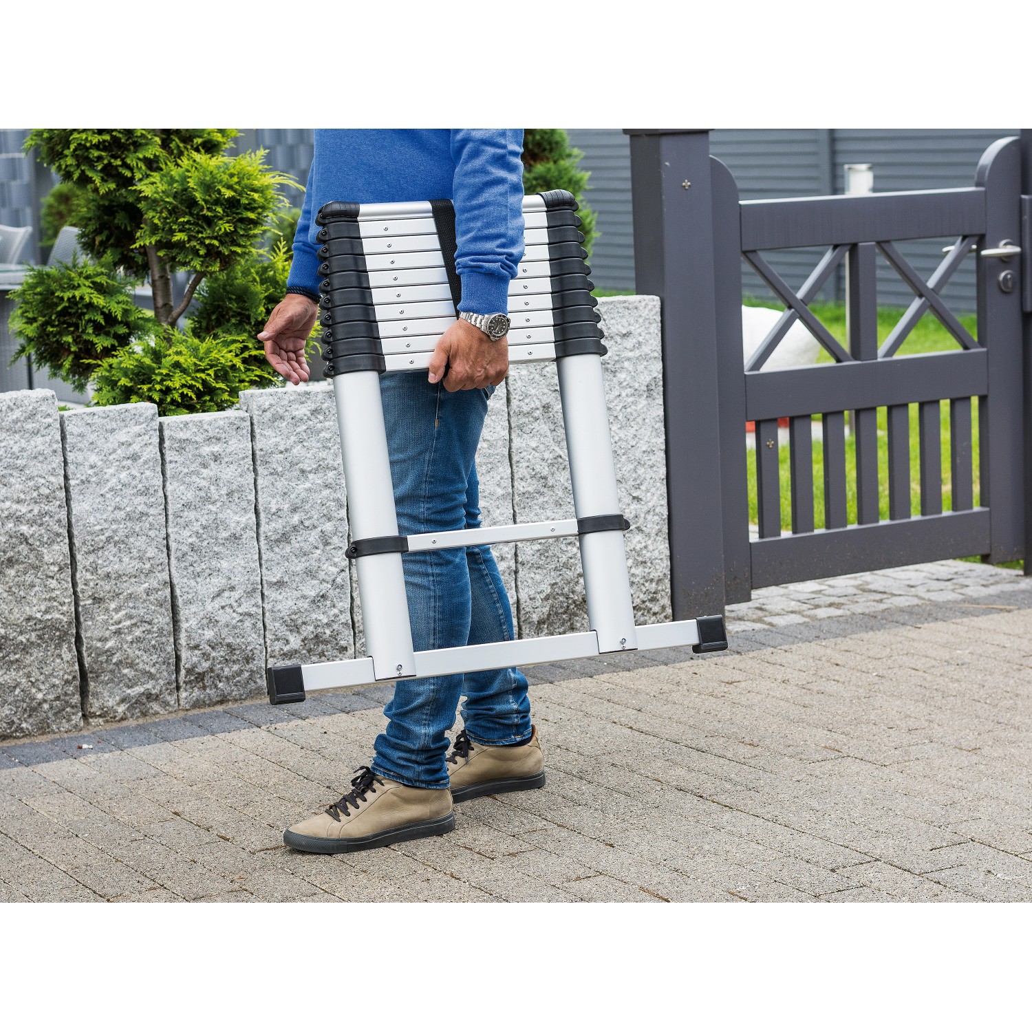 Zusammengeklappte Aluminium Teleskopleiter mit 11 Stufen wird von einer Person getragen.