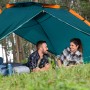 Bestway Zelt für 4 Personen mit Schnellaufbau, grün/orange, mit Paar im Zelt. Ideal für Camping.