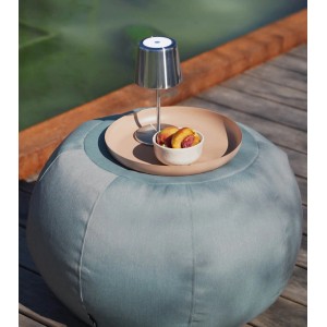 Himmelblauer, runder mokebo Outdoor Pouf 'Der Kugelige' als Sitzhocker mit Deko auf Terrasse.