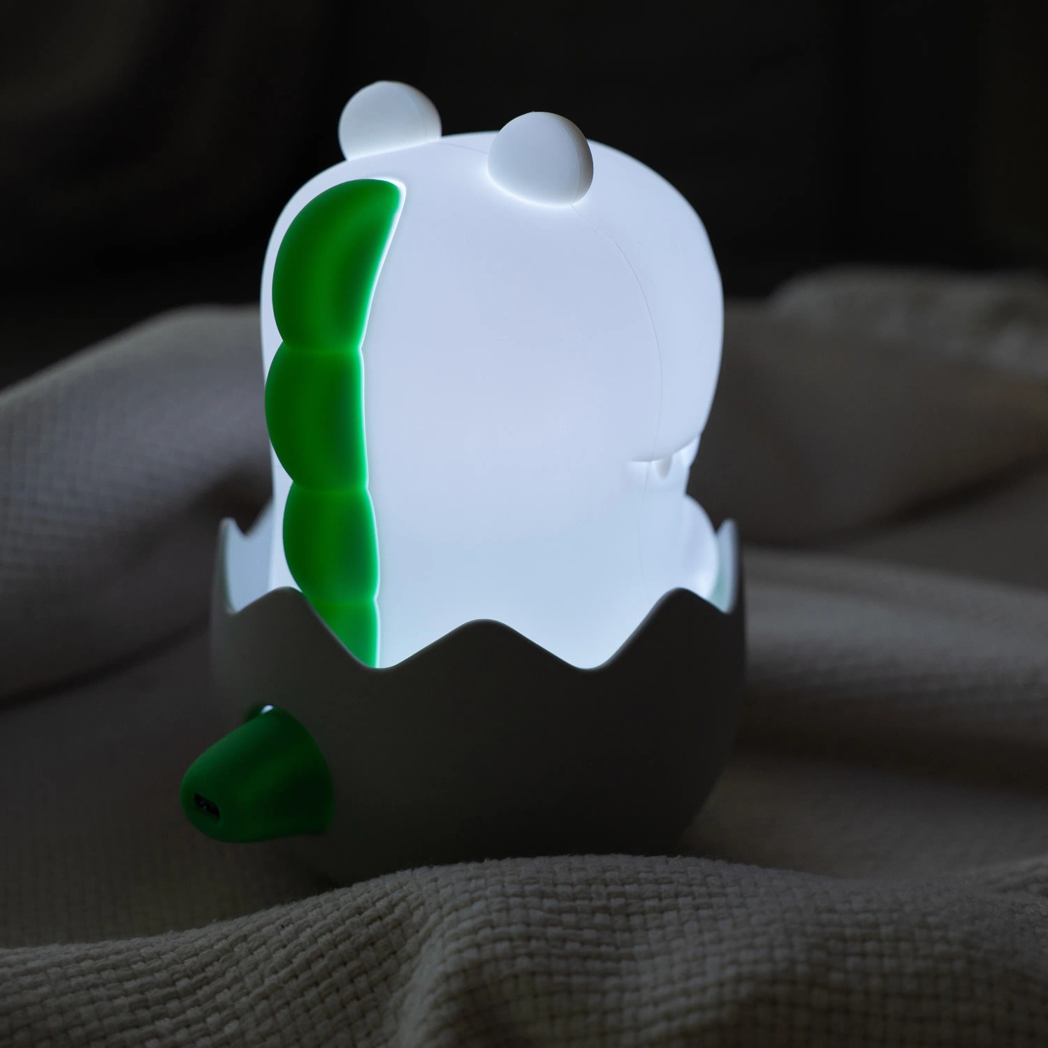 Dimmbares LED Kinder-Nachtlicht Diggy Dino RGBW in Eierschale, leuchtend.