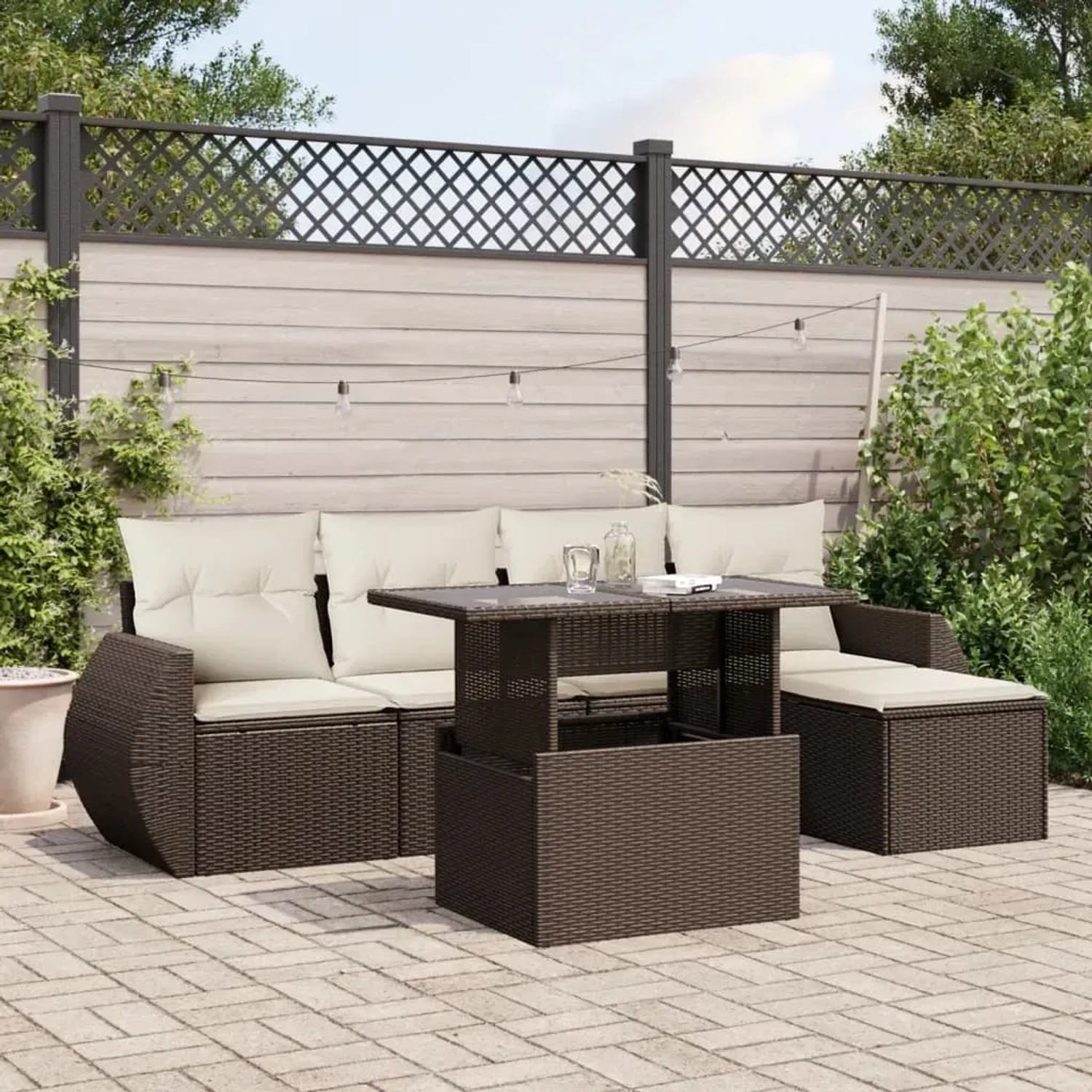 Braune 6-tlg. Garten-Sofagarnitur aus Rattan mit Tisch und cremefarbenen Kissen.