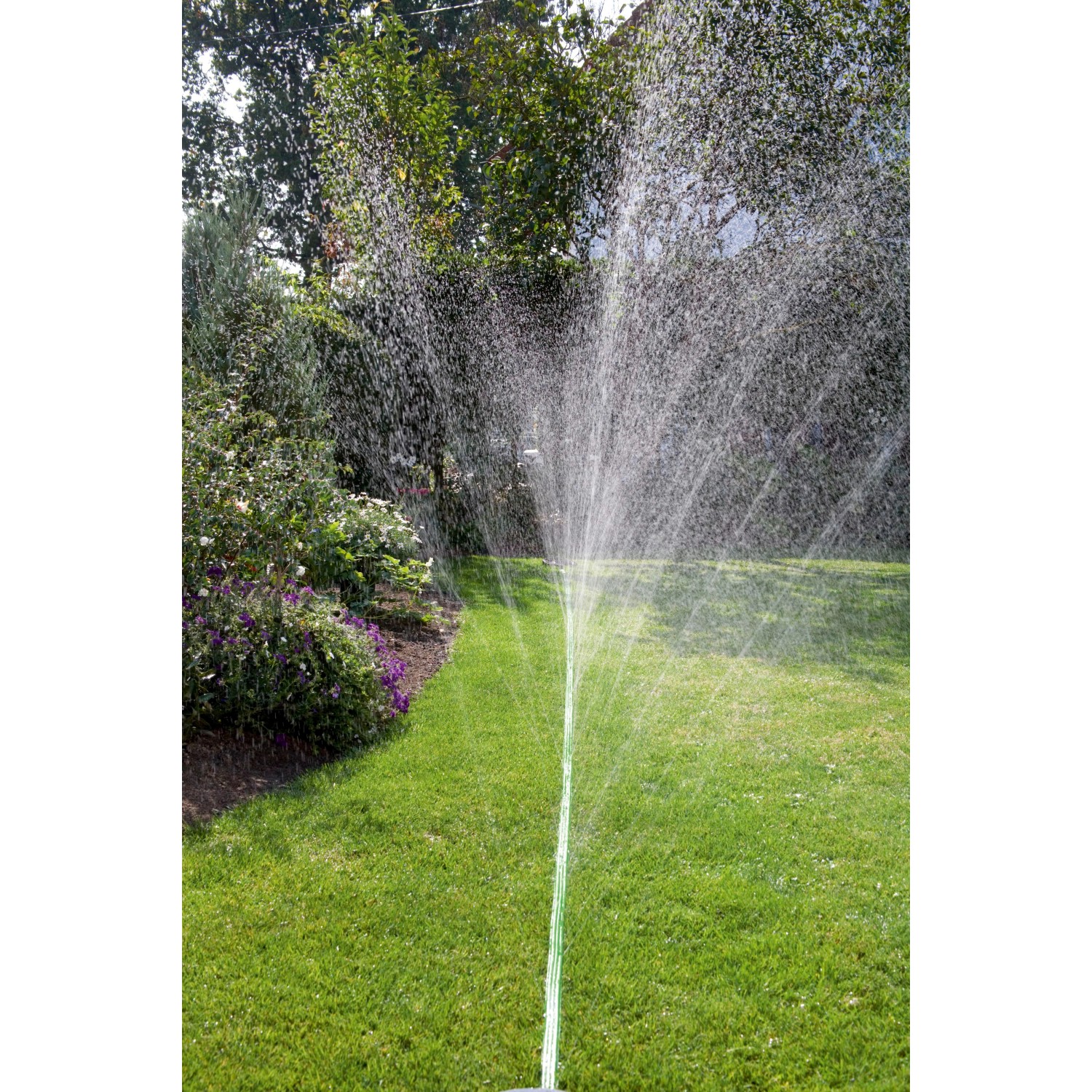 Gardena Schlauch-Regner (15 m, grün) im Einsatz, bewässert Rasenfläche mit feinem Sprühregen.