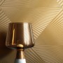 Goldene Vliestapete Aristeo mit modernem, strukturiertem Grafikmuster. Dekorative Wandgestaltung für Ihr Zuhause.