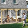 Skan Holz Terrassenüberdachung Bormio aus Leimholz mit klarer Polycarbonat-Dacheindeckung. Familienszene.