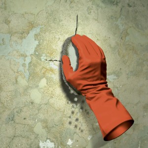Anwendung von MEM Wasser-Stopp: Hand mit Handschuh dichtet Riss in Wand ab.