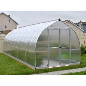 Silbernes Palram Canopia Bella Gewächshaus (6x2.4m) mit Stegplatten im Garten.