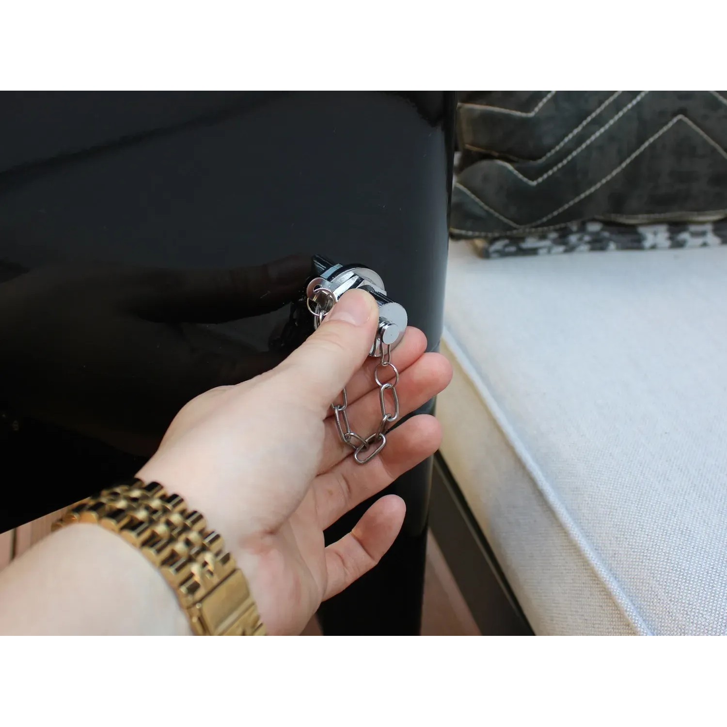 Detailaufnahme: Hand öffnet Flaschenöffner am schwarzen Axi Kühlwagen Retro 76 l.