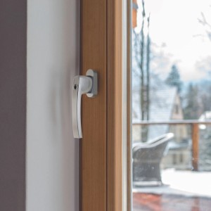 Abschließbarer Basi Fenstergriff FG 503, silber, im Holzfenster montiert.