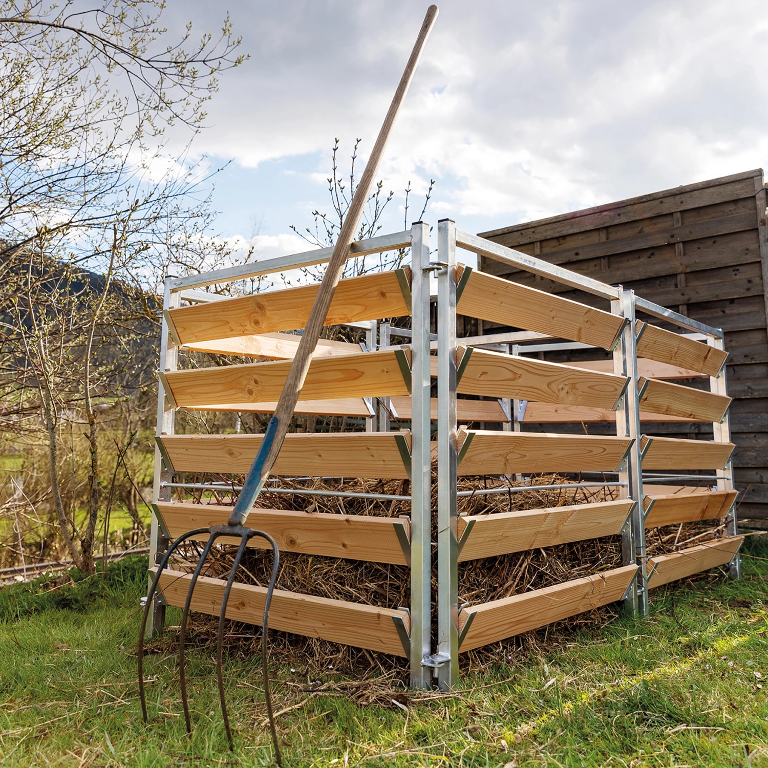 Bellissa Komposter Erweiterungsset aus Holz und Metall mit Kompostgabel im Garten.